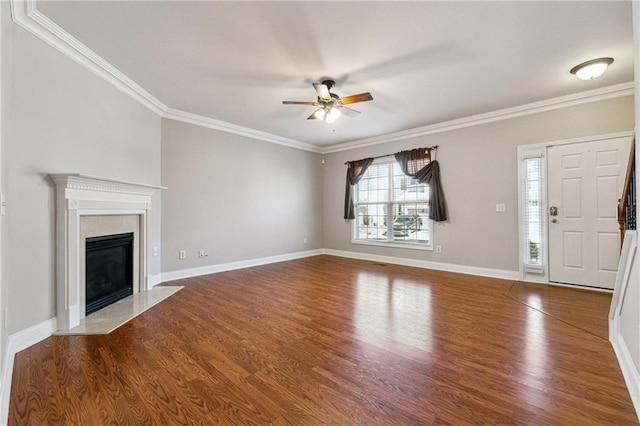 unfurnished living room featuring baseboards, crown molding, a premium fireplace, and wood finished floors