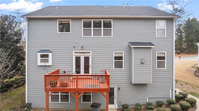 back of property with roof with shingles and a wooden deck