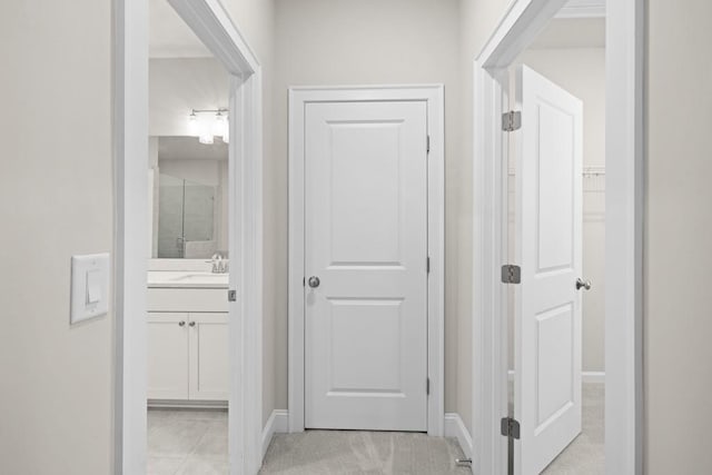 hallway with light tile patterned floors and sink