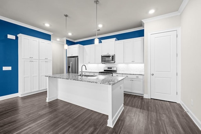 kitchen featuring white cabinetry, an island with sink, appliances with stainless steel finishes, light stone countertops, and sink