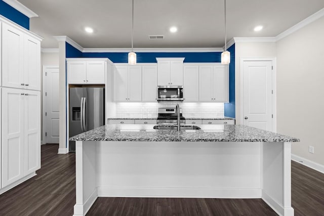 kitchen featuring white cabinetry, an island with sink, stainless steel appliances, hanging light fixtures, and sink