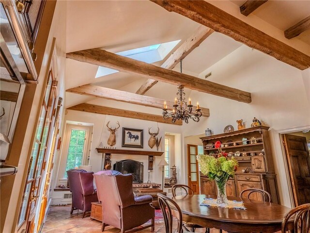 dining space featuring beamed ceiling, a skylight, an inviting chandelier, and high vaulted ceiling