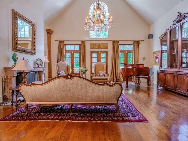 living room with high vaulted ceiling, wood-type flooring, and a chandelier