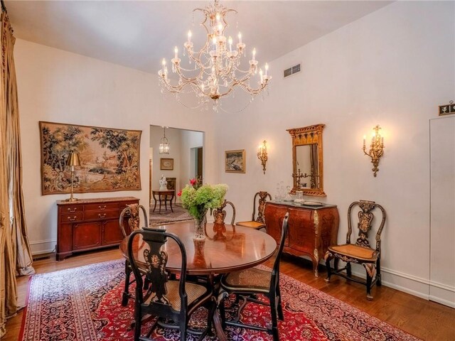 dining area with hardwood / wood-style flooring and a chandelier