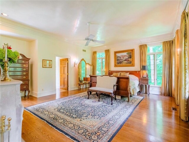 living area featuring ceiling fan, ornamental molding, and light wood-type flooring