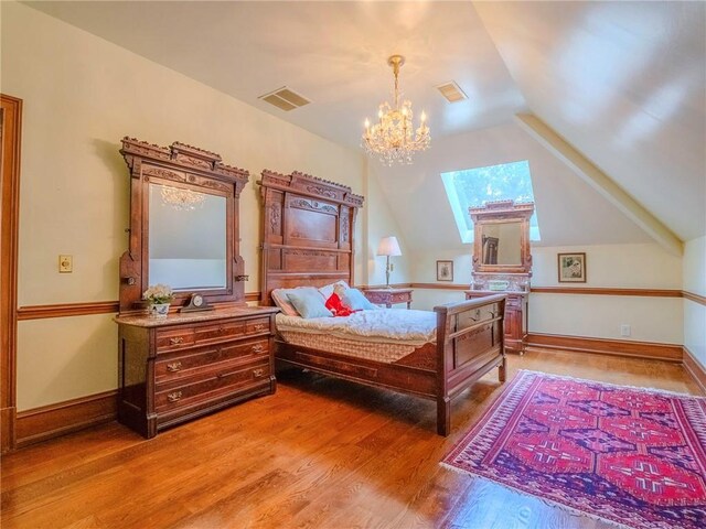 bedroom featuring hardwood / wood-style floors, a chandelier, and vaulted ceiling