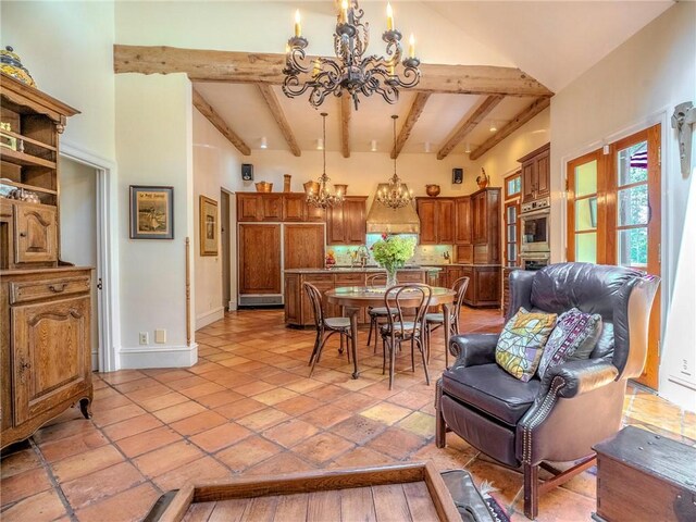 dining area with beamed ceiling, a chandelier, sink, and high vaulted ceiling