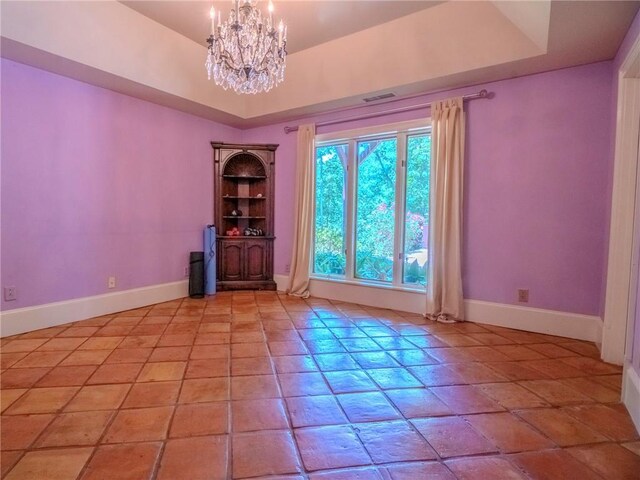 unfurnished room featuring built in shelves, a raised ceiling, a chandelier, and light tile patterned flooring