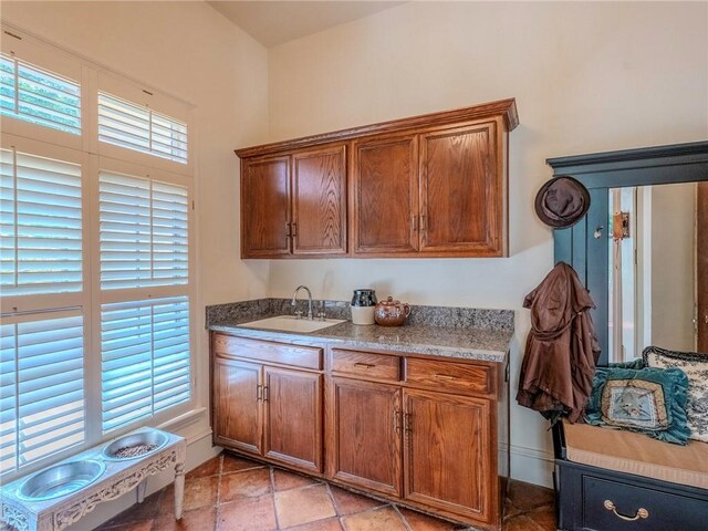 kitchen featuring light stone counters and sink