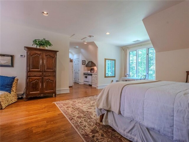 bedroom with lofted ceiling and light hardwood / wood-style floors