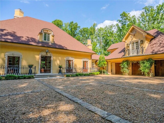 back of house featuring a garage and covered porch