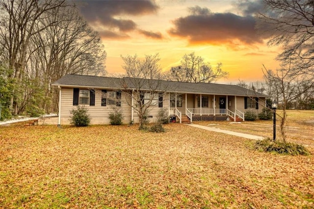 single story home with a porch and a lawn