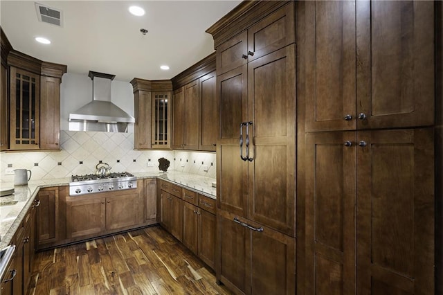 kitchen with light stone counters, visible vents, stainless steel gas cooktop, dark wood-type flooring, and wall chimney exhaust hood