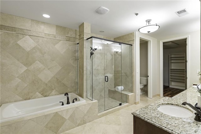 full bathroom with visible vents, toilet, a shower stall, a bath, and vanity