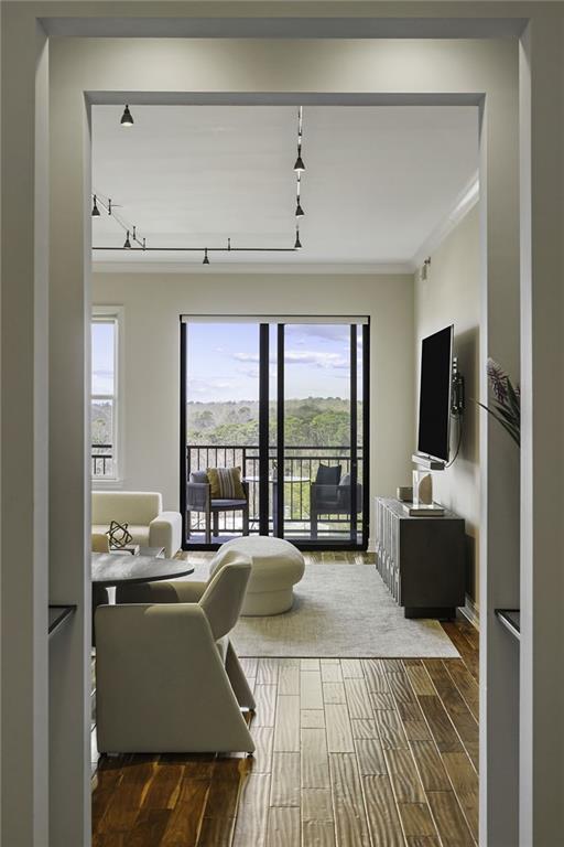 living area with ornamental molding and wood tiled floor