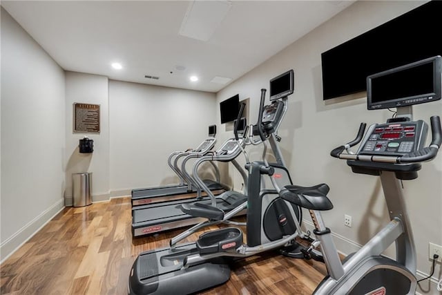 exercise area featuring recessed lighting, baseboards, and wood finished floors