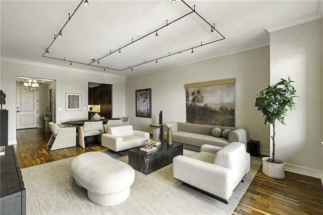 living room with baseboards, an inviting chandelier, track lighting, wood-type flooring, and crown molding