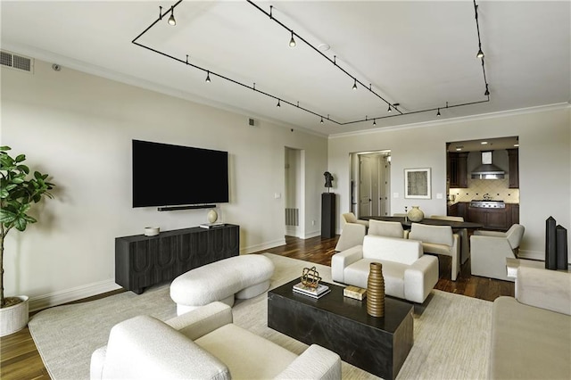 living area featuring rail lighting, visible vents, dark wood-style flooring, and baseboards