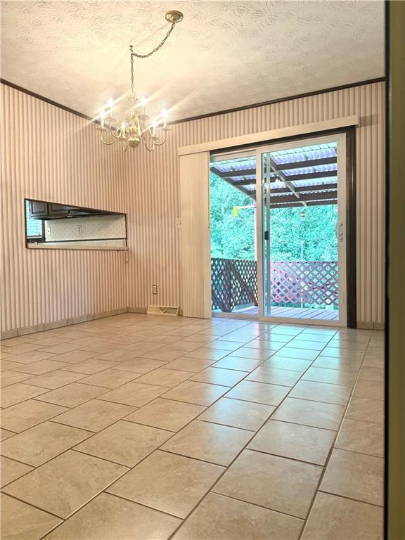 10 Montre Cir, Silver Creek, GA 30173 - empty room featuring a chandelier, light tile patterned floors, and a textured ceiling