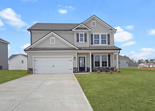 craftsman-style home featuring a garage, stone siding, concrete driveway, and a front yard