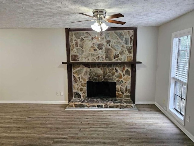 unfurnished living room with a textured ceiling, hardwood / wood-style floors, and a healthy amount of sunlight