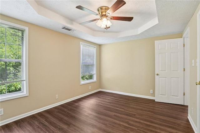 1039 Megan Ct, Sugar Hill, GA 30518 - unfurnished room featuring a raised ceiling, plenty of natural light, dark wood finished floors, and a textured ceiling