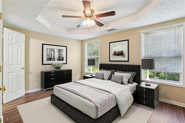 1039 Megan Ct, Sugar Hill, GA 30518 - bedroom with a tray ceiling, baseboards, wood finished floors, and a ceiling fan