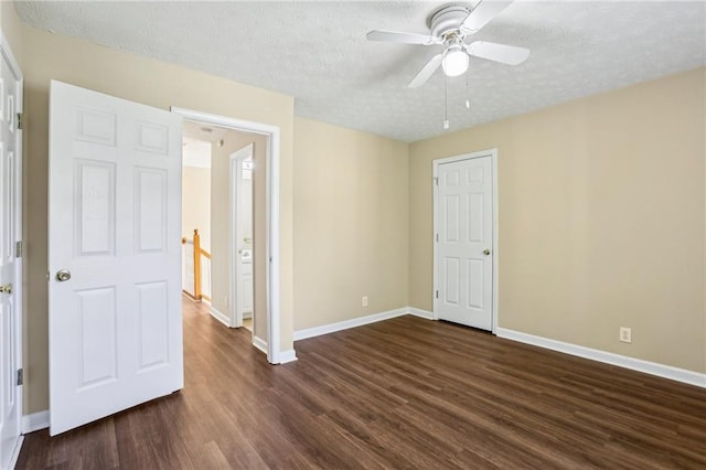 1039 Megan Ct, Sugar Hill, GA 30518 - unfurnished bedroom featuring dark wood-type flooring, baseboards, a textured ceiling, and ceiling fan