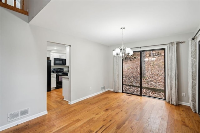 unfurnished dining area with light hardwood / wood-style floors and a chandelier