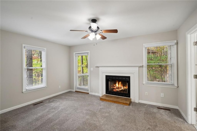 unfurnished living room featuring ceiling fan and light carpet