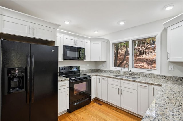 kitchen featuring sink, white cabinets, and black appliances