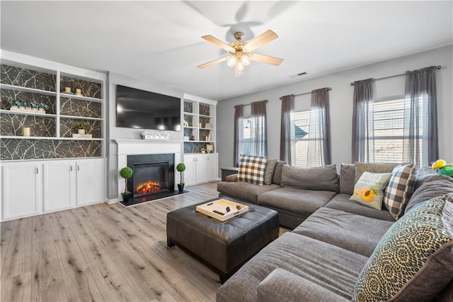 living room with ceiling fan and light hardwood / wood-style flooring