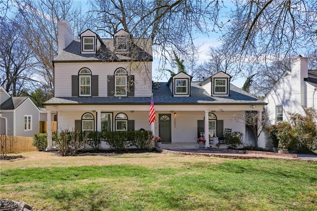 view of front of home with a front lawn, fence, and covered porch