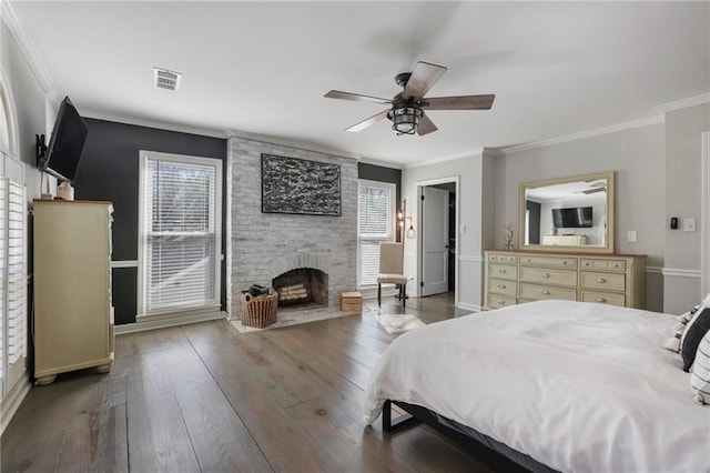 bedroom with visible vents, multiple windows, a fireplace, and wood-type flooring