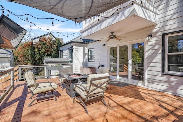 wooden deck with a ceiling fan and an outdoor fire pit