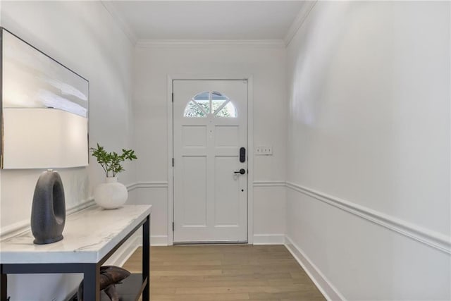 entrance foyer with baseboards, light wood finished floors, and ornamental molding