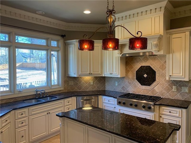 kitchen featuring appliances with stainless steel finishes, dark stone countertops, pendant lighting, and sink