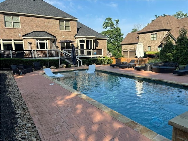 view of swimming pool with a patio area and a wooden deck