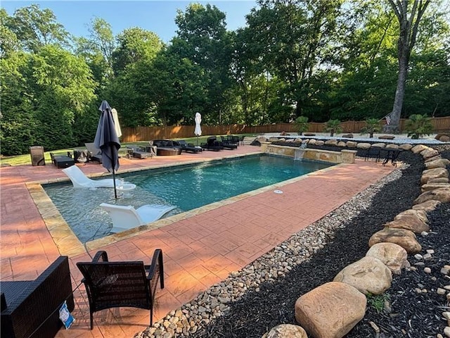 view of swimming pool featuring pool water feature and a patio