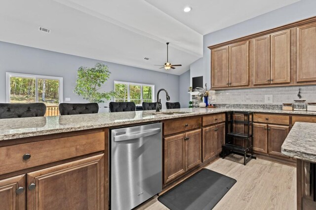 kitchen featuring decorative backsplash, stainless steel dishwasher, sink, and a wealth of natural light