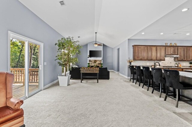 interior space featuring vaulted ceiling, ceiling fan, and light colored carpet