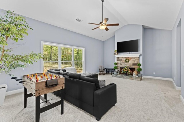 living room featuring a fireplace, lofted ceiling, ceiling fan, and light colored carpet