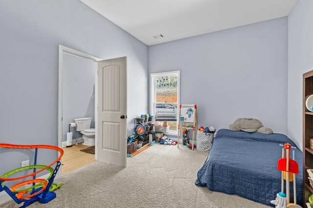 carpeted bedroom featuring ensuite bathroom