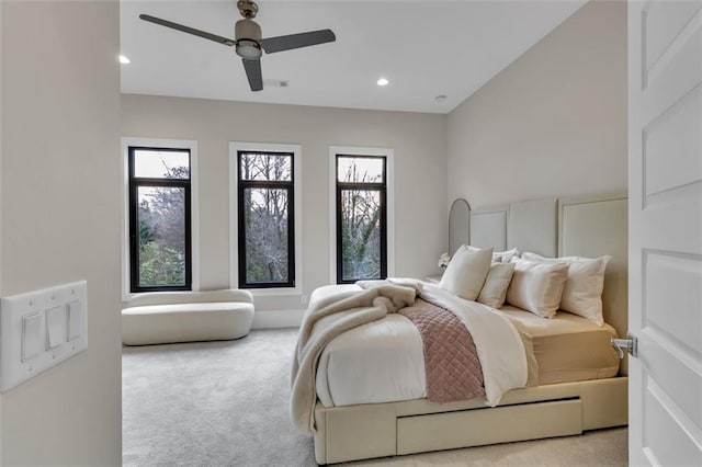 carpeted bedroom featuring ceiling fan and multiple windows