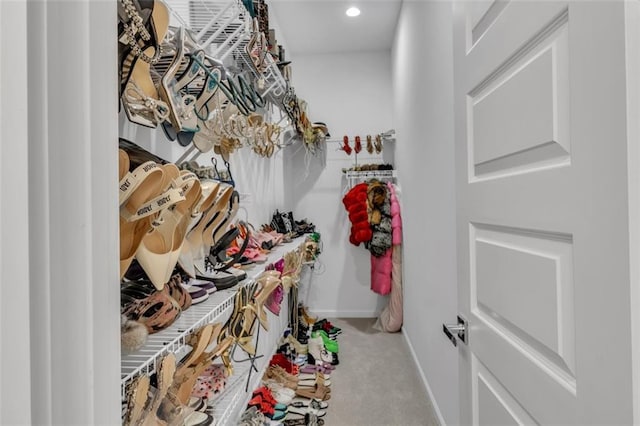 spacious closet featuring light colored carpet