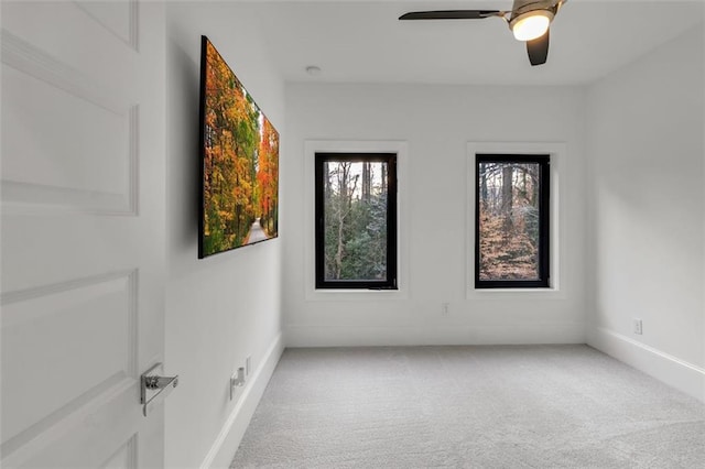 carpeted spare room with ceiling fan