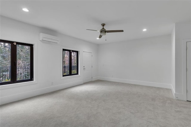 spare room featuring light colored carpet, an AC wall unit, and ceiling fan