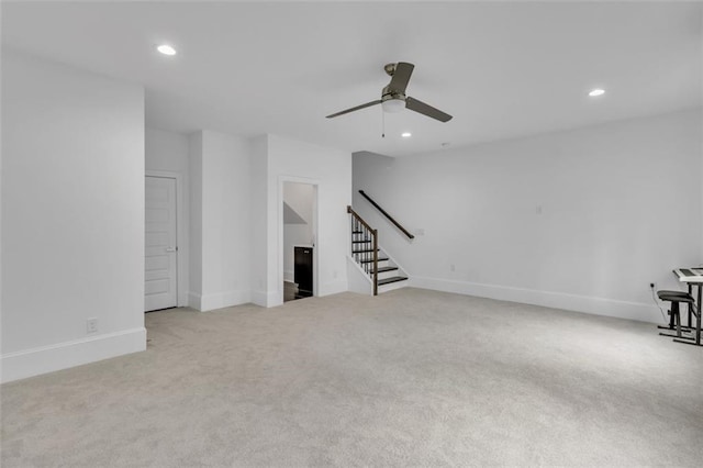 unfurnished living room featuring light carpet and ceiling fan