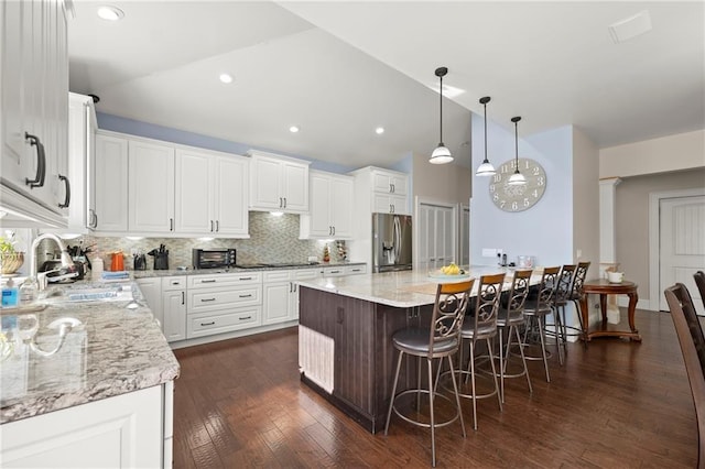 kitchen featuring stainless steel fridge, a center island, white cabinets, and dark hardwood / wood-style floors