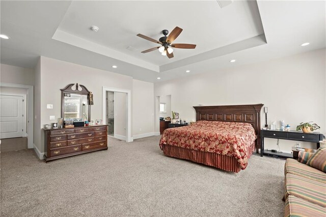 carpeted bedroom featuring ceiling fan and a tray ceiling